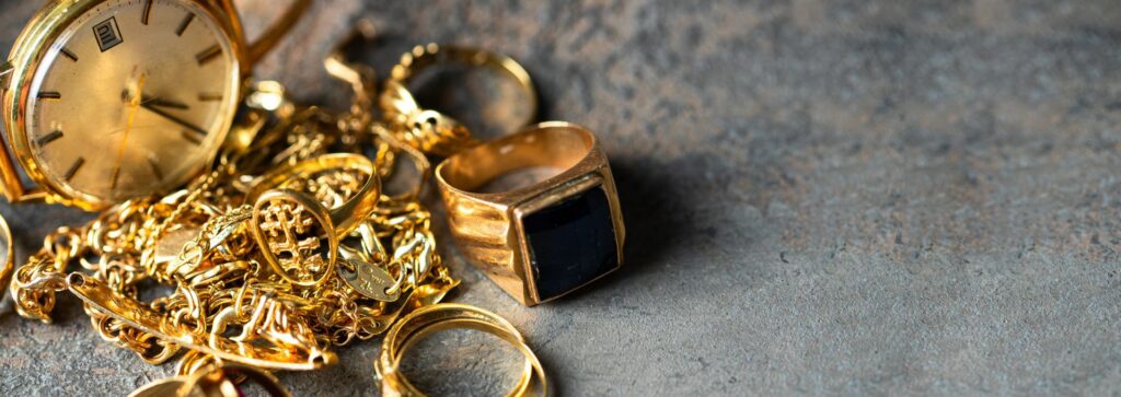 Goldschmuck, Goldringe, Goldketten und eine Armbanduhr als typische Altgold-Positionen beim Altgoldankauf. Die Aufnahme veranschaulicht die professionelle Bewertung und den Ankauf von Altgold und nicht mehr getragenem Goldschmuck.