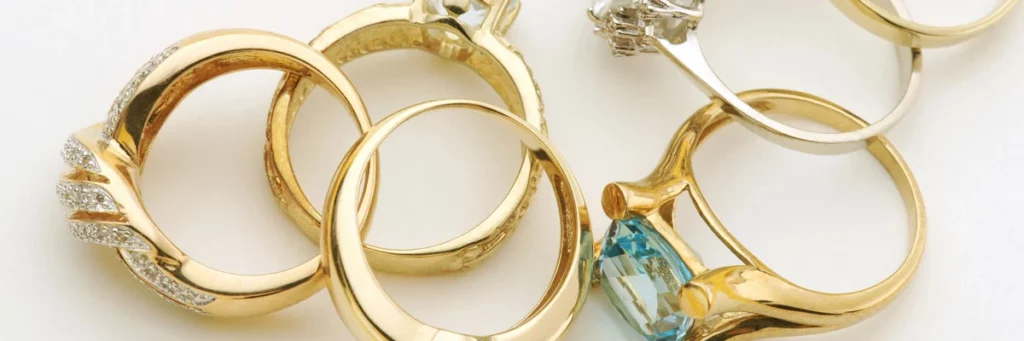 Goldringe mit Diamanten und farbigem Edelstein als Beispiel für hochwertigen Markenschmuck. Die Darstellung veranschaulicht den Verkauf von Markenschmuck in Heidelberg sowie die fachgerechte Wertermittlung und den Ankauf von exklusivem Designer- und Luxus-Schmuck.