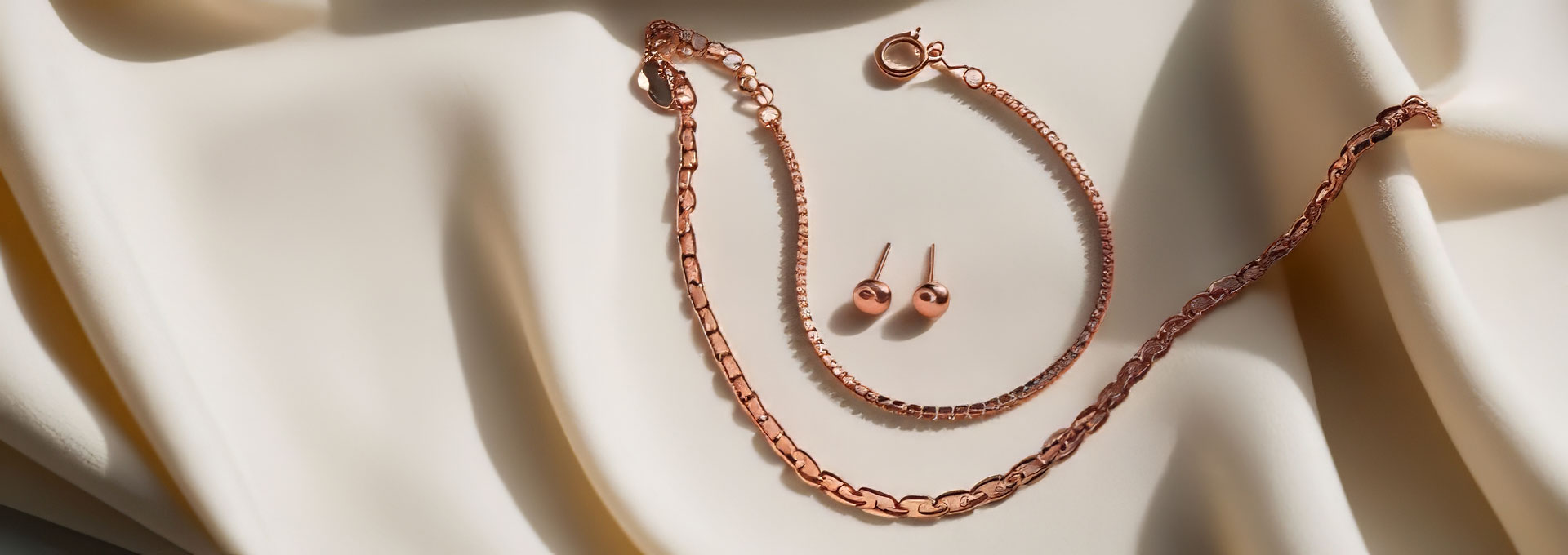 Roségoldschmuck mit Kette, Armband und Ohrsteckern in stilvoller Präsentation. Die Darstellung veranschaulicht den Schmuckankauf und den Verkauf von Goldschmuck zu fairen Preisen nach professioneller Wertermittlung.